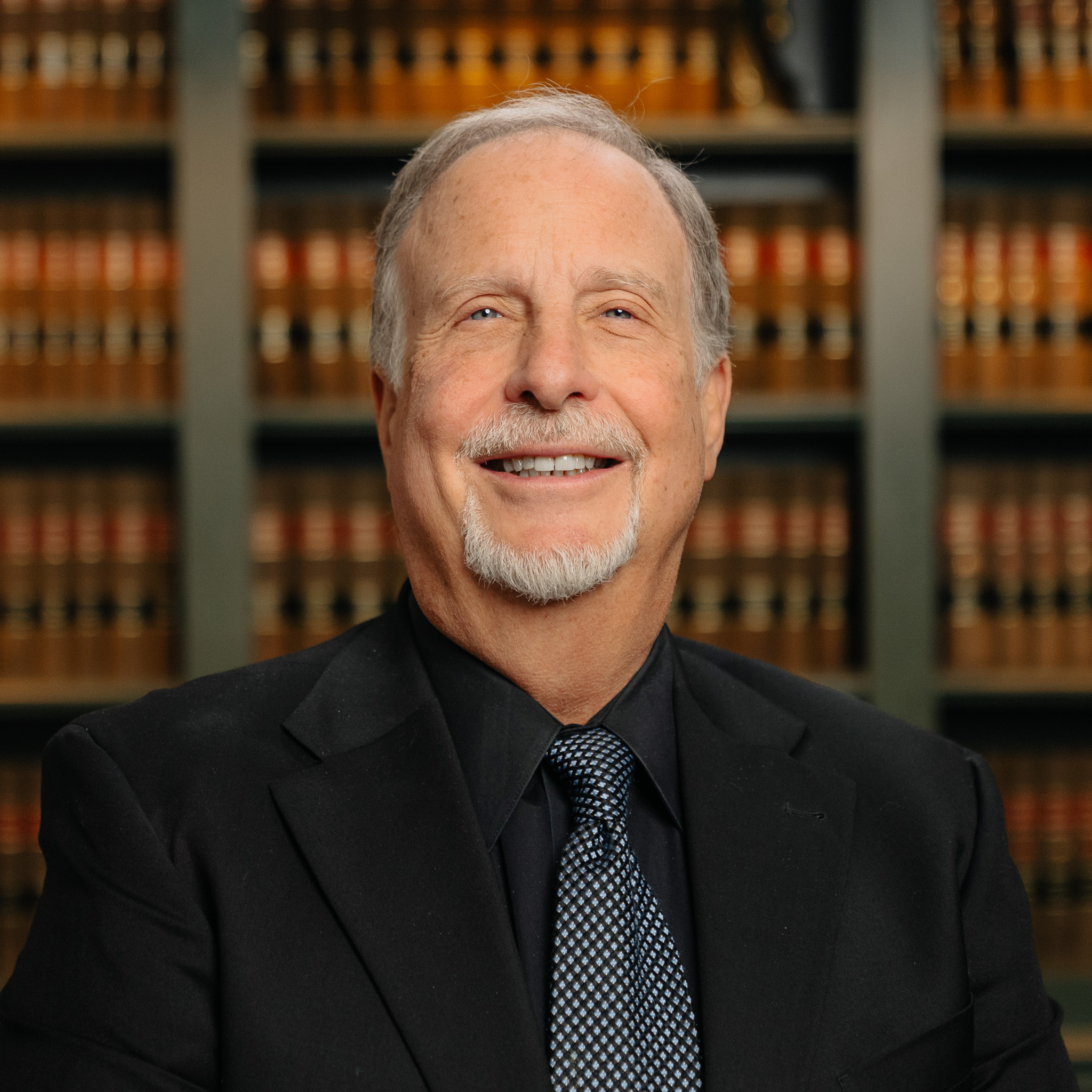 headshot of attorney Alan-Helmkamp in Northville, MI in front of a shelf of books