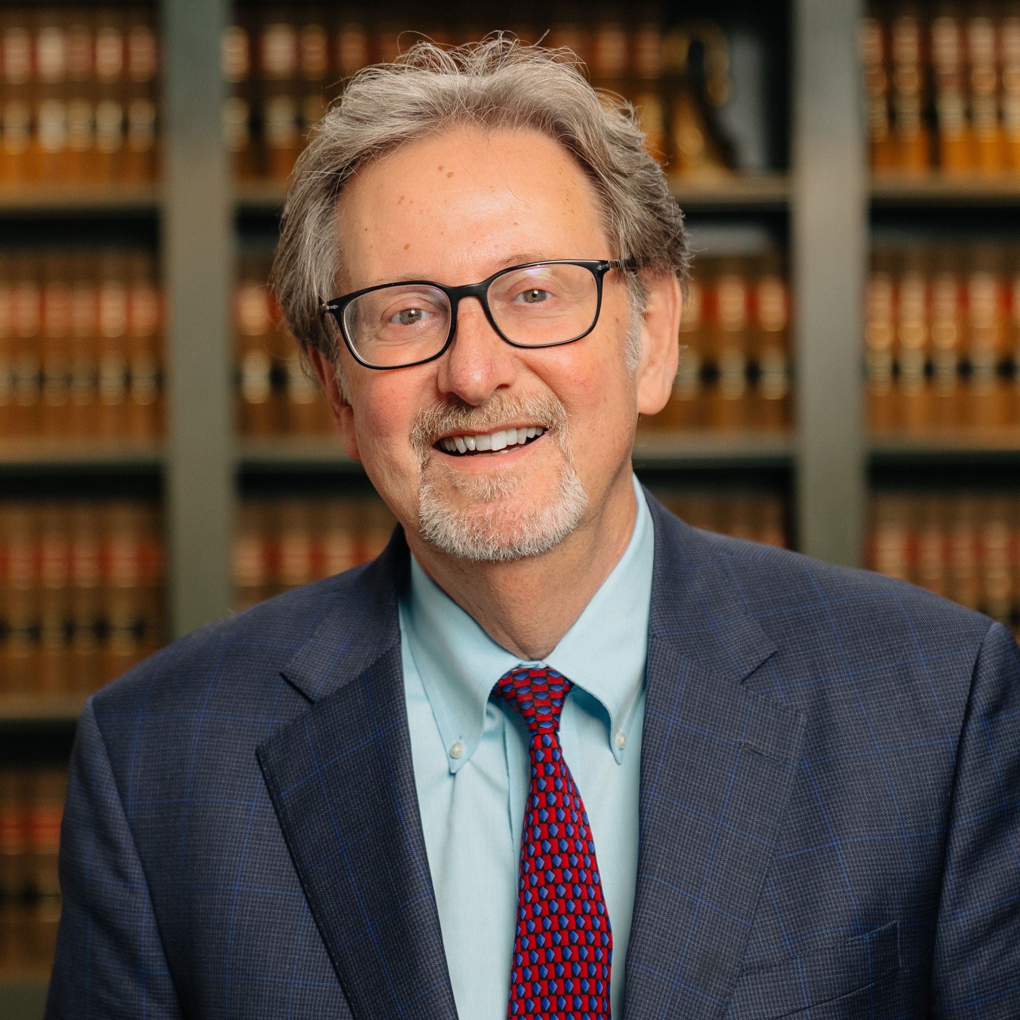 headshot of attorney Douglas C. Abraham in Northville, MI in front of a shelf of books