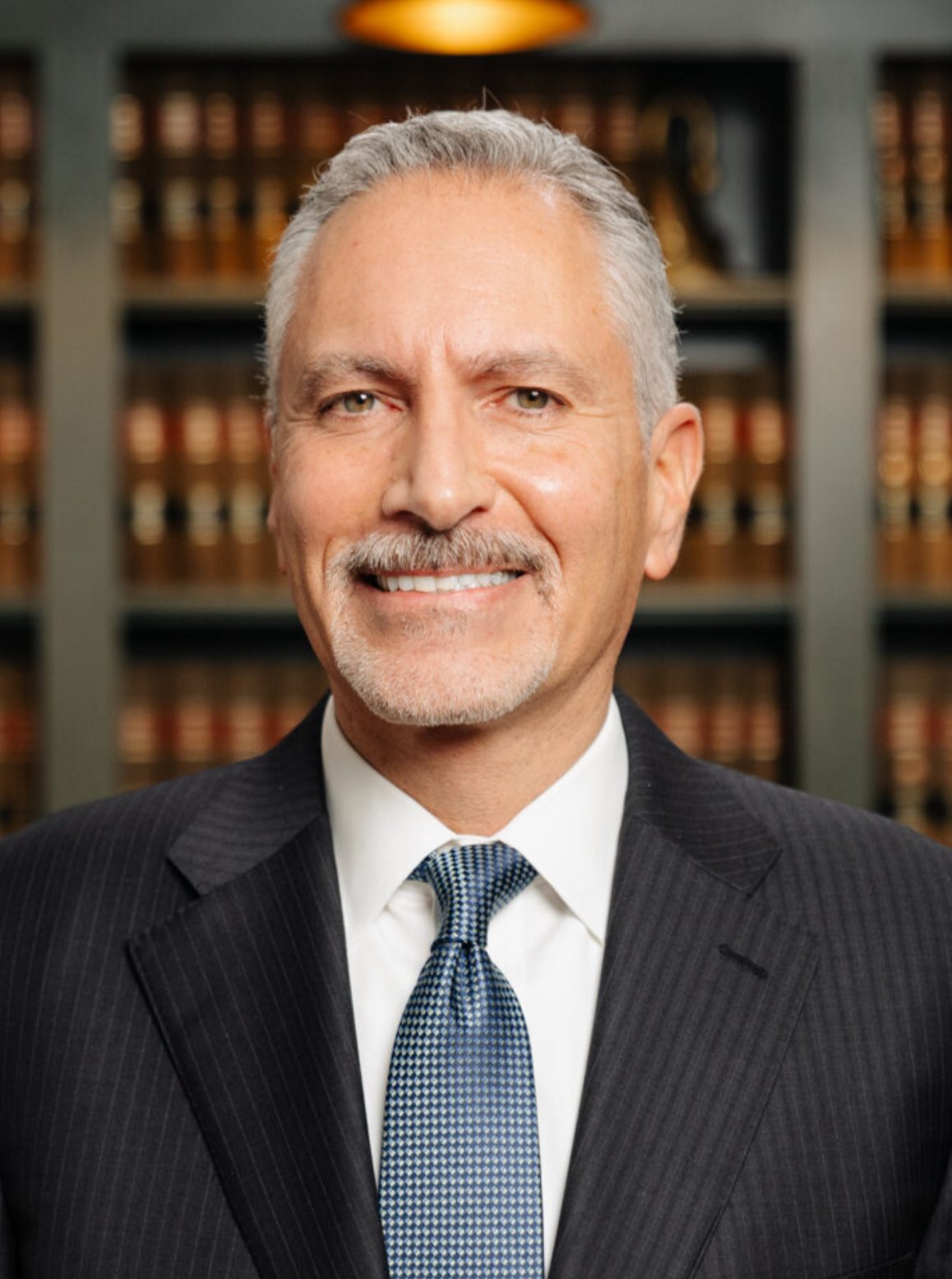 headshot of attorney Jeffrey Ghannam in Northville, MI in front of a shelf of books