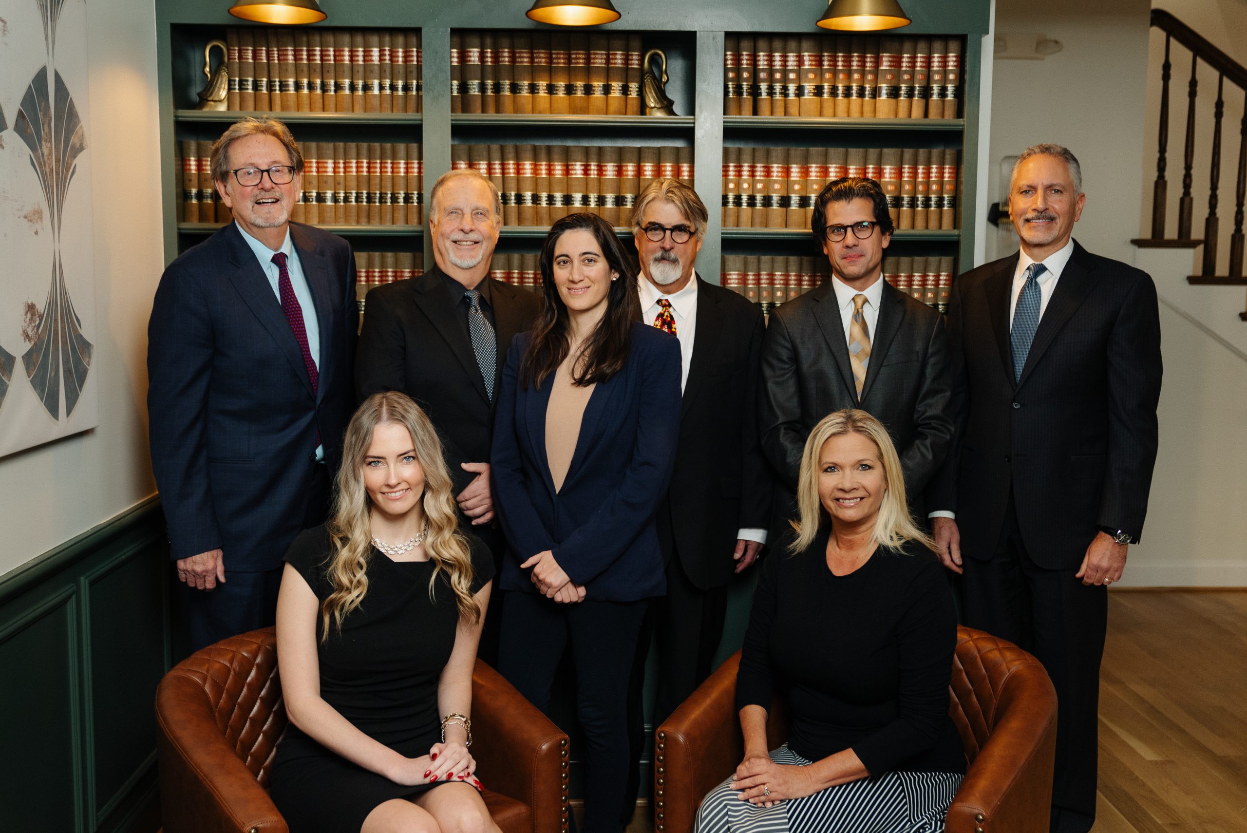 The team of Helmkamp, Ellis, Abraham, and Engerer in the lobby of the firm with five men standing, one woman standing, and two women seated in leather chairs.